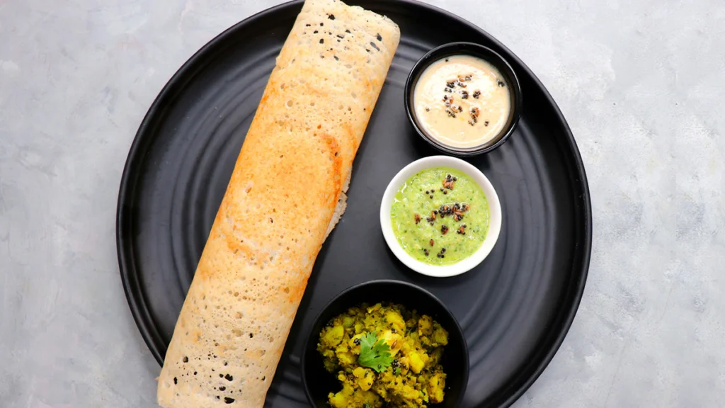 Crispy golden masala dosa filled with spiced potato, served with chutney and sambar